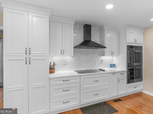 8117 Spivey Rd, Jonesboro, GA 30236 - kitchen featuring wall chimney exhaust hood, double oven, black electric cooktop, white cabinets, and recessed lighting