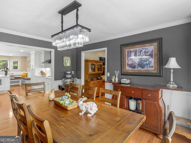 8117 Spivey Rd, Jonesboro, GA 30236 - dining area featuring light wood-style floors, crown molding, and a chandelier