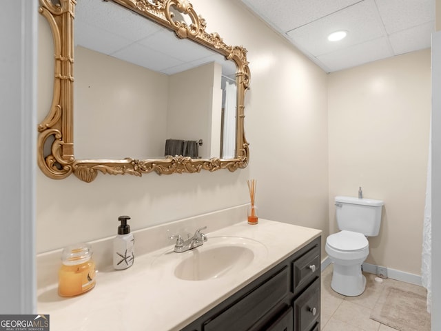 8117 Spivey Rd, Jonesboro, GA 30236 - full bath featuring a paneled ceiling, vanity, toilet, tile patterned flooring, and baseboards