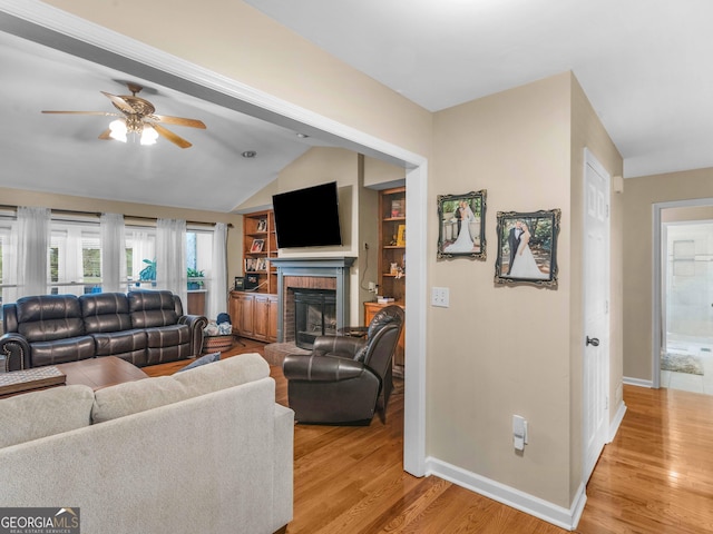 8117 Spivey Rd, Jonesboro, GA 30236 - living area with ceiling fan, baseboards, light wood-style flooring, a brick fireplace, and lofted ceiling
