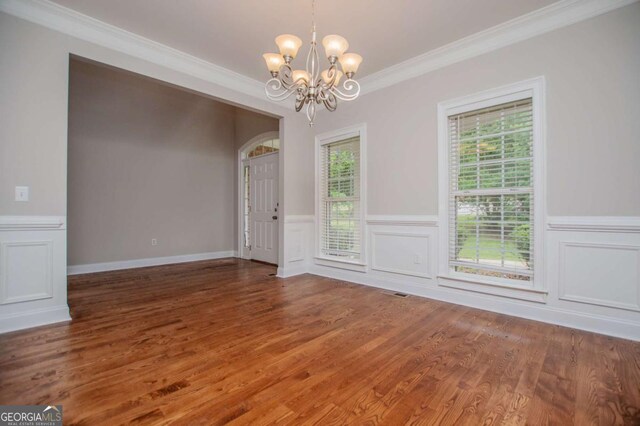 5995 Azalea Ridge Dr, Douglasville, GA 30135 - unfurnished room with a chandelier, ornamental molding, plenty of natural light, wood finished floors, and a wainscoted wall
