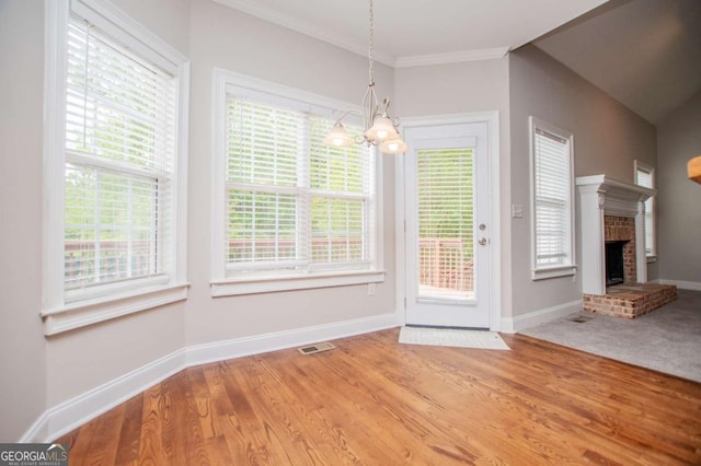 5995 Azalea Ridge Dr, Douglasville, GA 30135 - unfurnished dining area featuring a chandelier, baseboards, ornamental molding, a brick fireplace, and wood finished floors