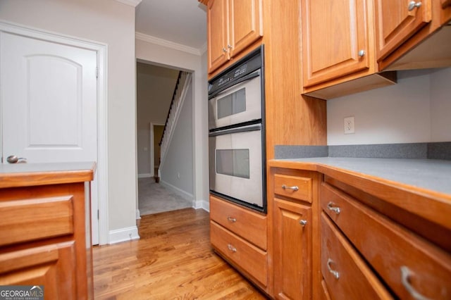 5995 Azalea Ridge Dr, Douglasville, GA 30135 - kitchen featuring stainless steel double oven, crown molding, light wood-style flooring, light countertops, and brown cabinetry
