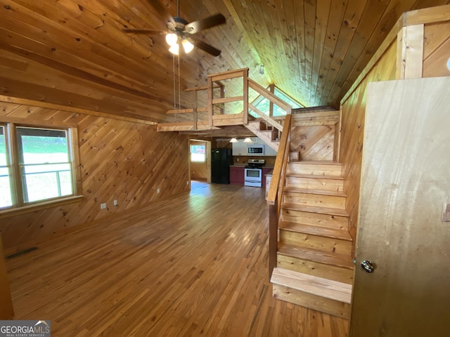interior space featuring wood ceiling, wood walls, stairway, hardwood / wood-style flooring, and vaulted ceiling