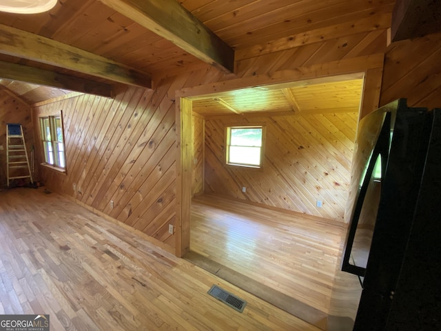 additional living space with wood-type flooring, wooden walls, healthy amount of natural light, and wood ceiling