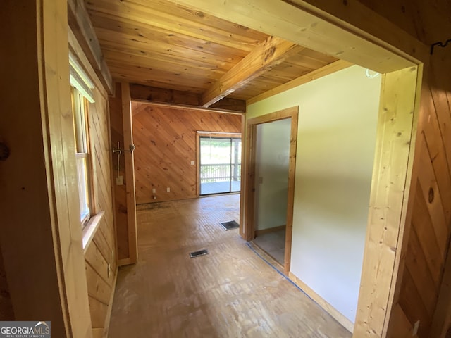 hallway with wood ceiling, wooden walls, and beamed ceiling