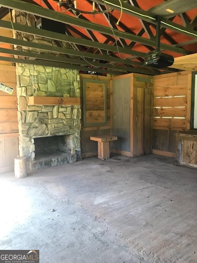 16 Tuts Mountain Rd, Clayton, GA 30525 - unfurnished living room with a fireplace, unfinished concrete flooring, wood walls, and a garage