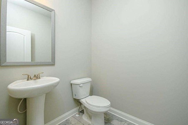 3018 Old Covington Rd Unit 3, Covington, GA 30014 - half bathroom featuring toilet, baseboards, and a sink
