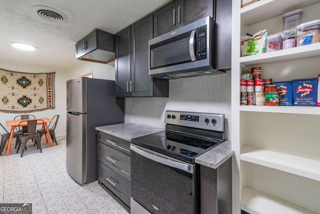 1902 Athens Hwy, Jefferson, GA 30549 - kitchen with appliances with stainless steel finishes, light countertops, a textured ceiling, decorative backsplash, and light tile patterned flooring