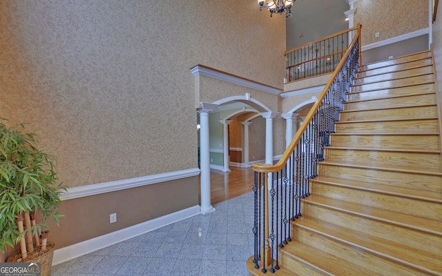 194 Winding Way, Hartwell, GA 30643 - stairway with decorative columns, granite tiled floors, baseboards, arched walkways, and a chandelier