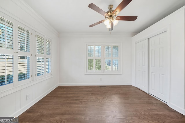 1831 Dresden Dr, Brookhaven, GA 30319 - unfurnished bedroom featuring multiple windows, dark wood-type flooring, crown molding, a closet, and a ceiling fan