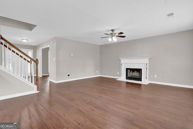 1280 Chandler Ridge Dr, Lawrenceville, GA 30045 - unfurnished living room with ceiling fan, stairs, dark wood finished floors, and a tile fireplace
