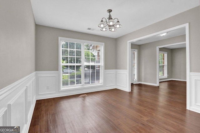 1280 Chandler Ridge Dr, Lawrenceville, GA 30045 - unfurnished dining area with a chandelier, a wainscoted wall, dark wood-style flooring, and a decorative wall