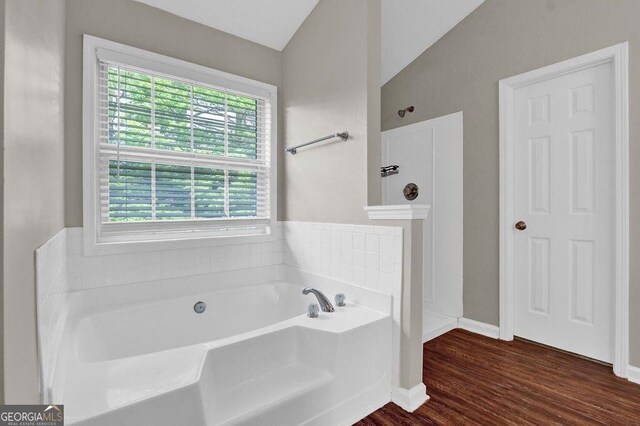 1280 Chandler Ridge Dr, Lawrenceville, GA 30045 - bathroom with a garden tub, vaulted ceiling, and wood finished floors