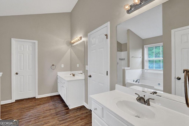 1280 Chandler Ridge Dr, Lawrenceville, GA 30045 - full bathroom with two vanities, wood finished floors, a garden tub, and a shower