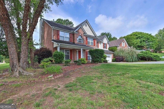 1280 Chandler Ridge Dr, Lawrenceville, GA 30045 - traditional-style house featuring brick siding, a front yard, an attached garage, and a porch