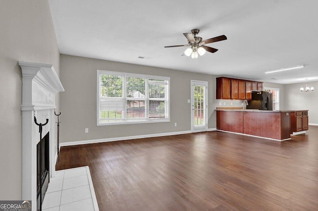 1280 Chandler Ridge Dr, Lawrenceville, GA 30045 - unfurnished living room with dark wood-style flooring, healthy amount of natural light, a ceiling fan, and a fireplace with flush hearth