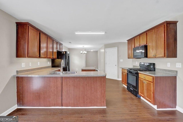 1280 Chandler Ridge Dr, Lawrenceville, GA 30045 - kitchen featuring black appliances, a peninsula, dark wood finished floors, a chandelier, and light countertops