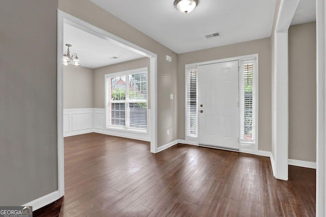 1280 Chandler Ridge Dr, Lawrenceville, GA 30045 - entryway with dark wood finished floors, a chandelier, and a wainscoted wall