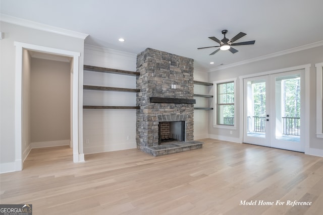 unfurnished living room featuring ceiling fan, ornamental molding, wood finished floors, french doors, and a fireplace