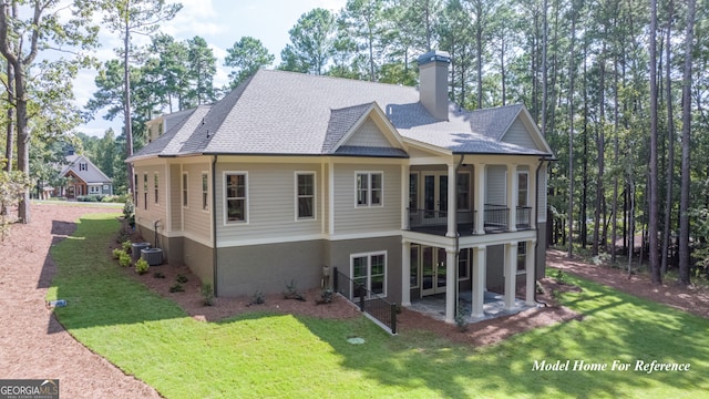rear view of property featuring a yard, a patio area, a chimney, and roof with shingles
