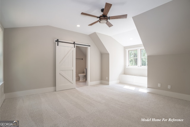 additional living space with lofted ceiling, a ceiling fan, a barn door, carpet flooring, and recessed lighting