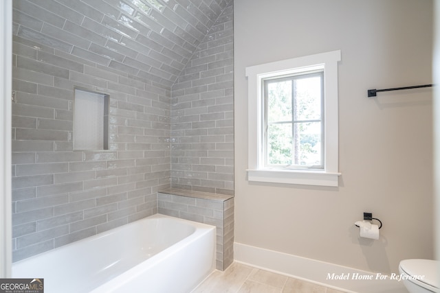 full bath featuring baseboards, toilet, and vaulted ceiling