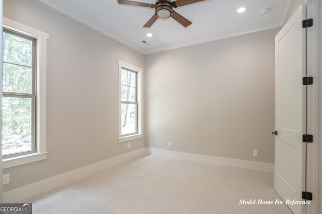 carpeted empty room with healthy amount of natural light, a ceiling fan, recessed lighting, ornamental molding, and baseboards