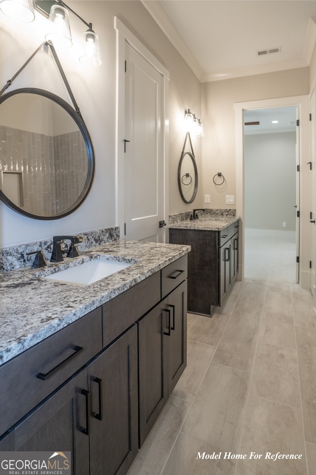 bathroom with two vanities and crown molding