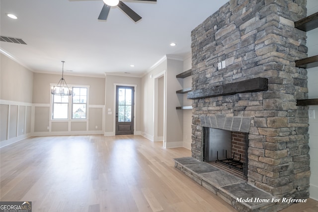 unfurnished living room with crown molding, light wood-style flooring, a stone fireplace, ceiling fan, and recessed lighting