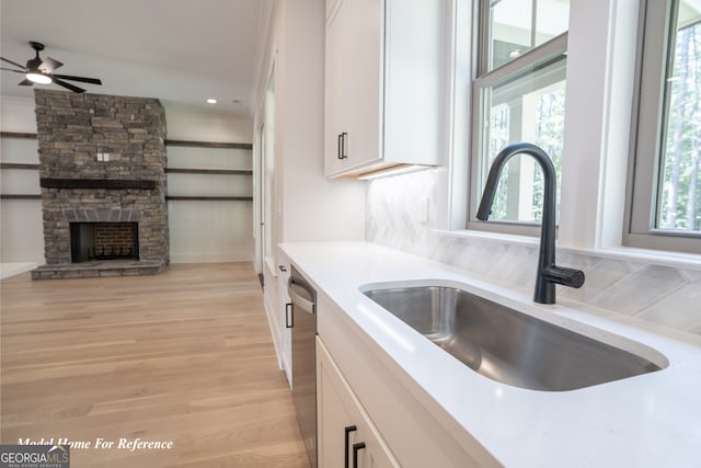 kitchen featuring a sink, white cabinetry, light countertops, ceiling fan, and light wood finished floors