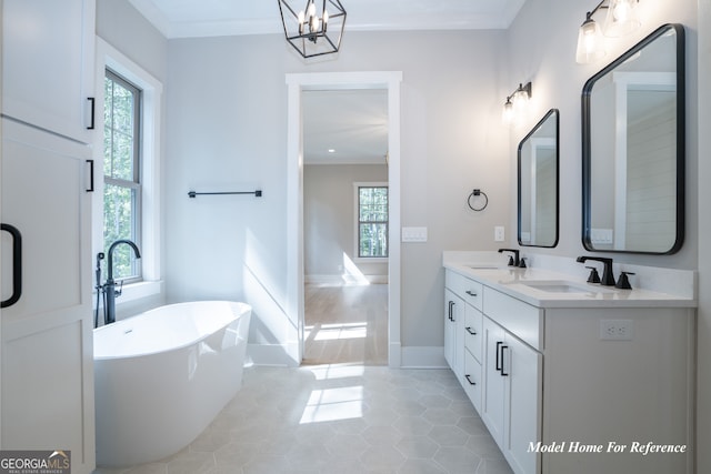 bathroom with ornamental molding, a soaking tub, double vanity, tile patterned flooring, and a chandelier
