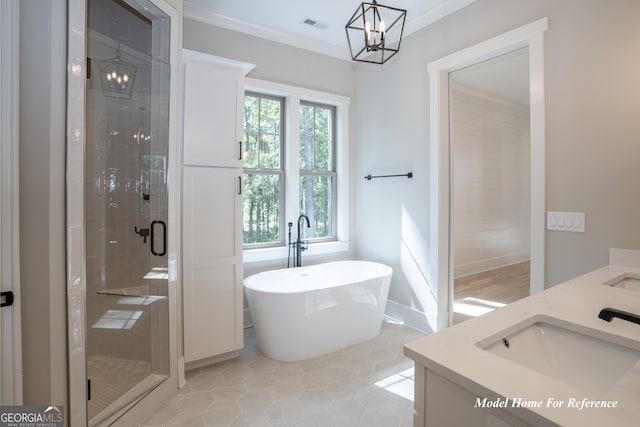 full bath featuring a shower stall, a freestanding tub, a chandelier, double vanity, and ornamental molding