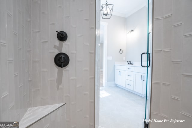 bathroom with a tile shower, crown molding, vanity, and tile patterned flooring