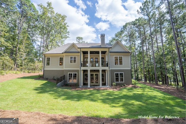 rear view of property featuring french doors, a chimney, a yard, and a balcony