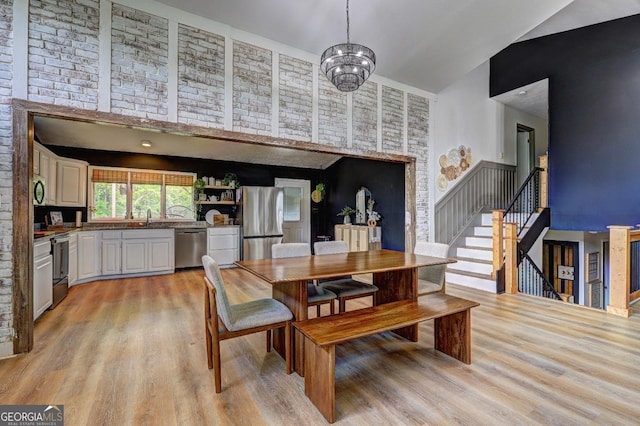 124 Laurel Dr, Barnesville, GA 30204 - dining space featuring high vaulted ceiling, light wood-style flooring, stairs, and a chandelier