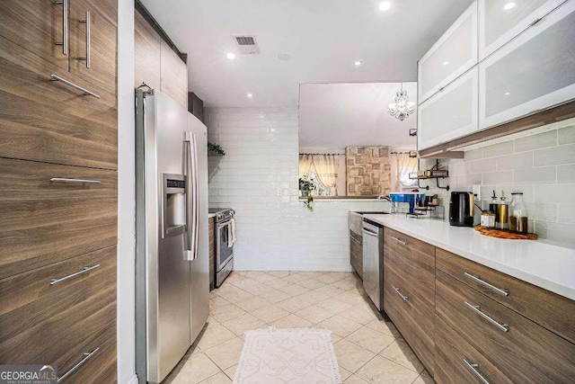 128 Graybrook Ct, Grayson, GA 30017 - kitchen with appliances with stainless steel finishes, light tile patterned floors, glass insert cabinets, light countertops, and backsplash