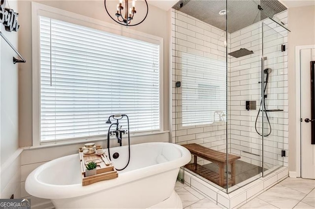 bathroom with a shower stall, a freestanding tub, marble look tile flooring, and healthy amount of natural light