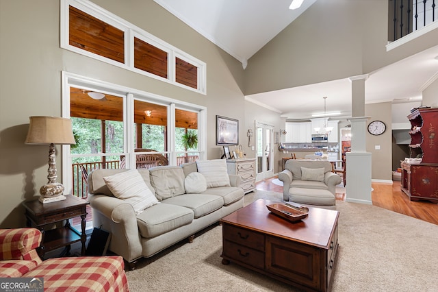 138 Knightwood Pt, Acworth, GA 30101 - living room featuring ornamental molding, high vaulted ceiling, light carpet, ornate columns, and baseboards