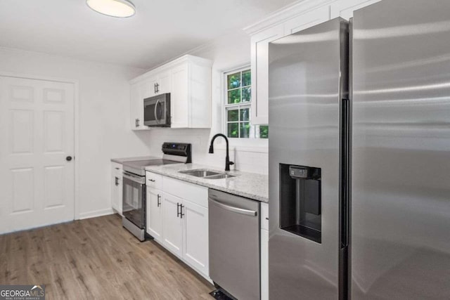 5155 Oakdale Ct, Douglasville, GA 30135 - kitchen featuring stainless steel appliances, a sink, light stone countertops, white cabinets, and light wood-type flooring