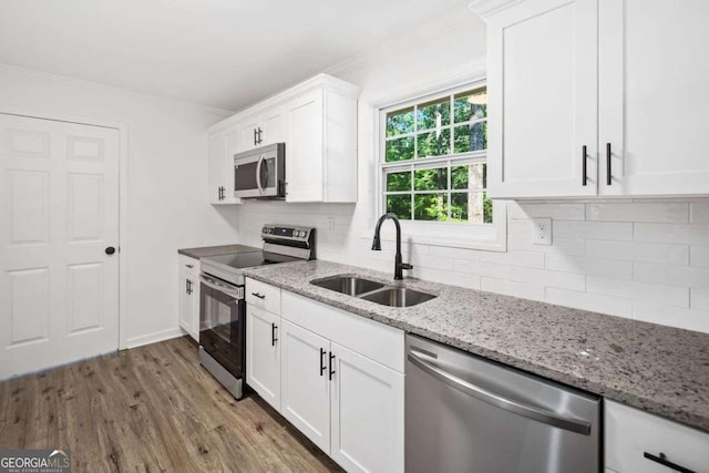 5155 Oakdale Ct, Douglasville, GA 30135 - kitchen featuring stainless steel appliances, a sink, white cabinetry, wood finished floors, and decorative backsplash