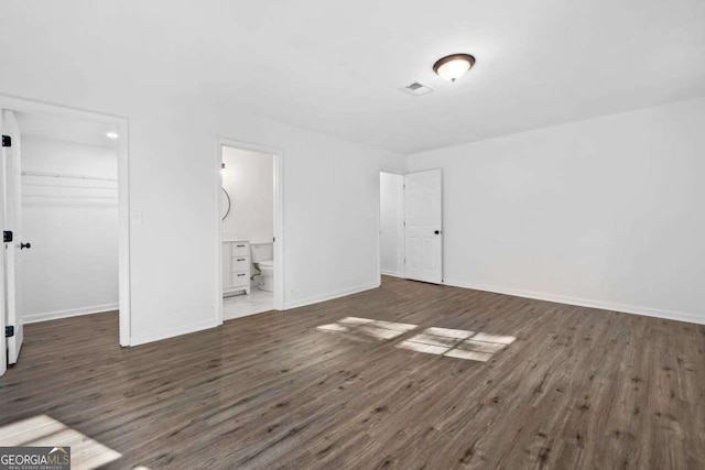 5155 Oakdale Ct, Douglasville, GA 30135 - unfurnished bedroom featuring wood finished floors, a walk in closet, a closet, baseboards, and connected bathroom