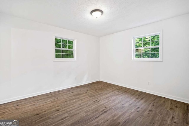 5155 Oakdale Ct, Douglasville, GA 30135 - unfurnished room with healthy amount of natural light, baseboards, dark wood finished floors, and a textured ceiling