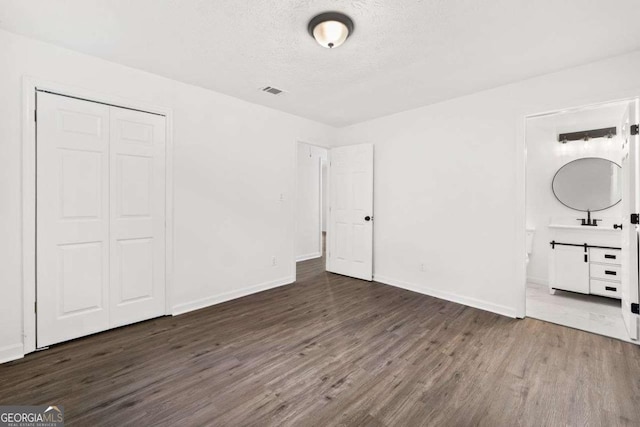 5155 Oakdale Ct, Douglasville, GA 30135 - unfurnished bedroom featuring wood finished floors, a textured ceiling, a closet, baseboards, and ensuite bathroom