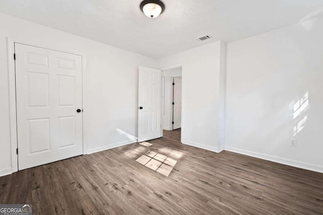 5155 Oakdale Ct, Douglasville, GA 30135 - unfurnished bedroom with baseboards, wood finished floors, and a textured ceiling