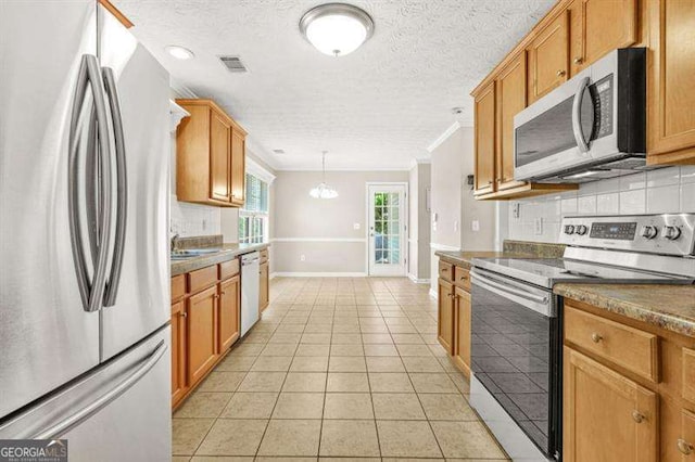 182 Garden Manor Ct, Loganville, GA 30052 - kitchen featuring appliances with stainless steel finishes, decorative backsplash, ornamental molding, a chandelier, and light tile patterned floors