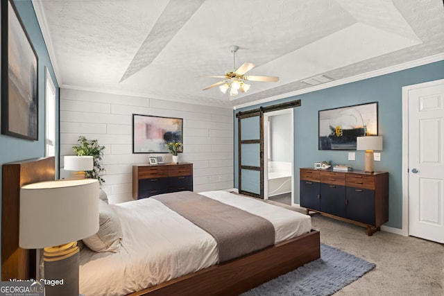 182 Garden Manor Ct, Loganville, GA 30052 - bedroom with a barn door, ornamental molding, a textured ceiling, light carpet, and a raised ceiling