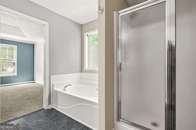 182 Garden Manor Ct, Loganville, GA 30052 - bathroom featuring a shower stall, healthy amount of natural light, a garden tub, and a textured ceiling