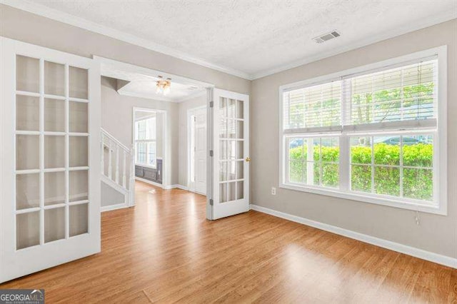 182 Garden Manor Ct, Loganville, GA 30052 - empty room with stairs, wood finished floors, ornamental molding, french doors, and a textured ceiling