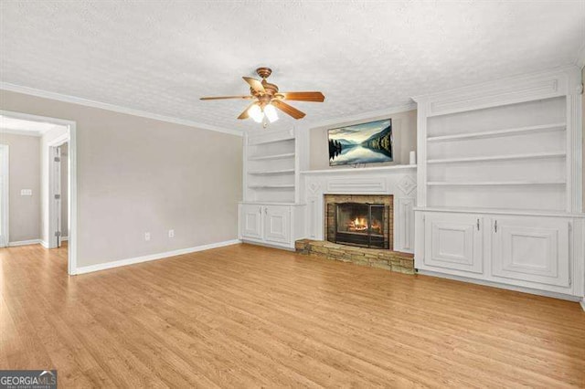 182 Garden Manor Ct, Loganville, GA 30052 - unfurnished living room featuring a ceiling fan, wood finished floors, built in features, a fireplace, and ornamental molding